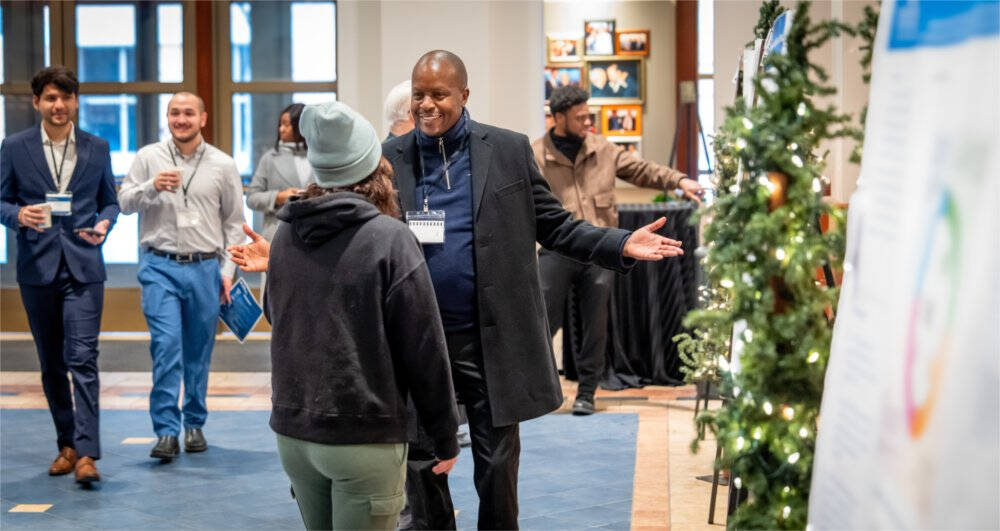 Student George Kirangu talks about his research project with graduate student Ali Belhrak at the College of Computing's Innovation Day